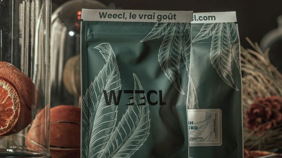 Изображение, представляющее логотип Weecl, веб-сайта, предлагающего промо-коды, купоны и ваучеры на скидку для покупок в Интернете.